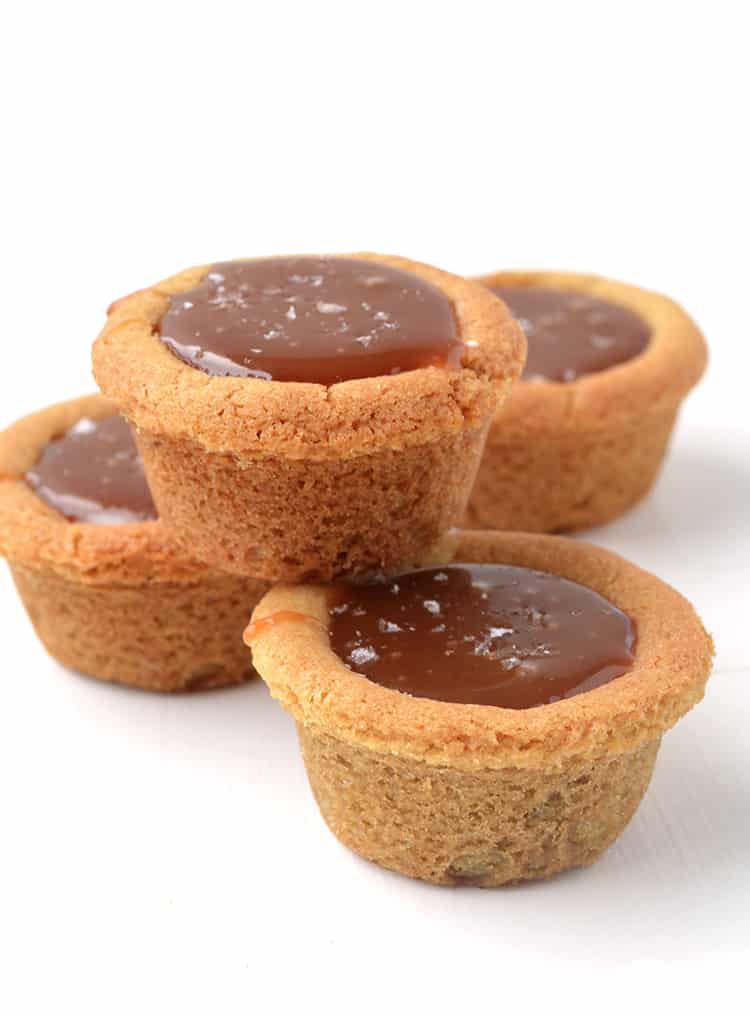 A stack of cookie cups filled with caramel sauce