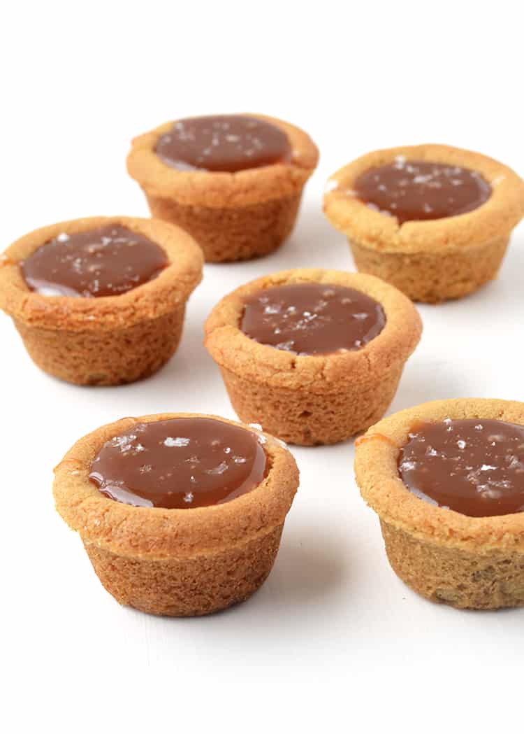 Cookies cups filled with caramel on a white background