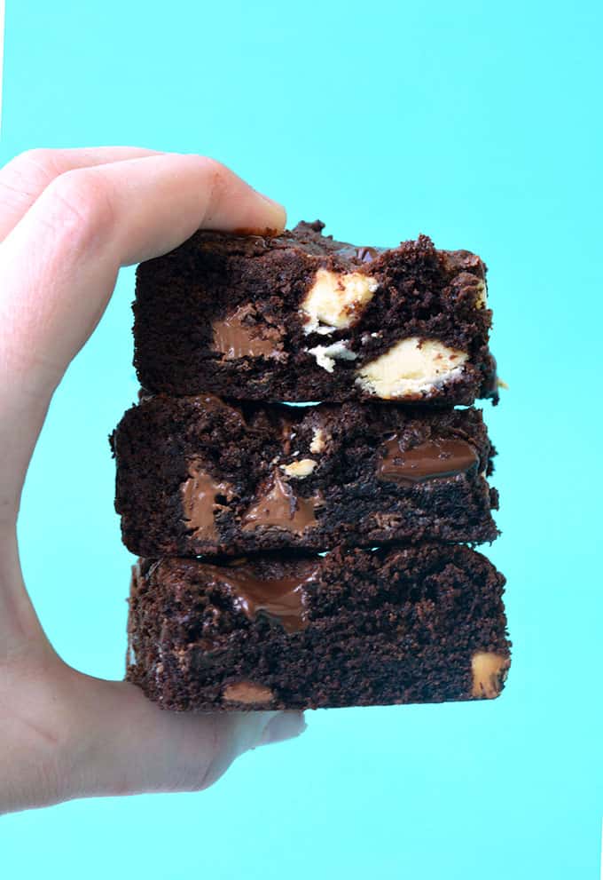 A hand holding a stack of Triple Chocolate Chunk Cookie Bars 
