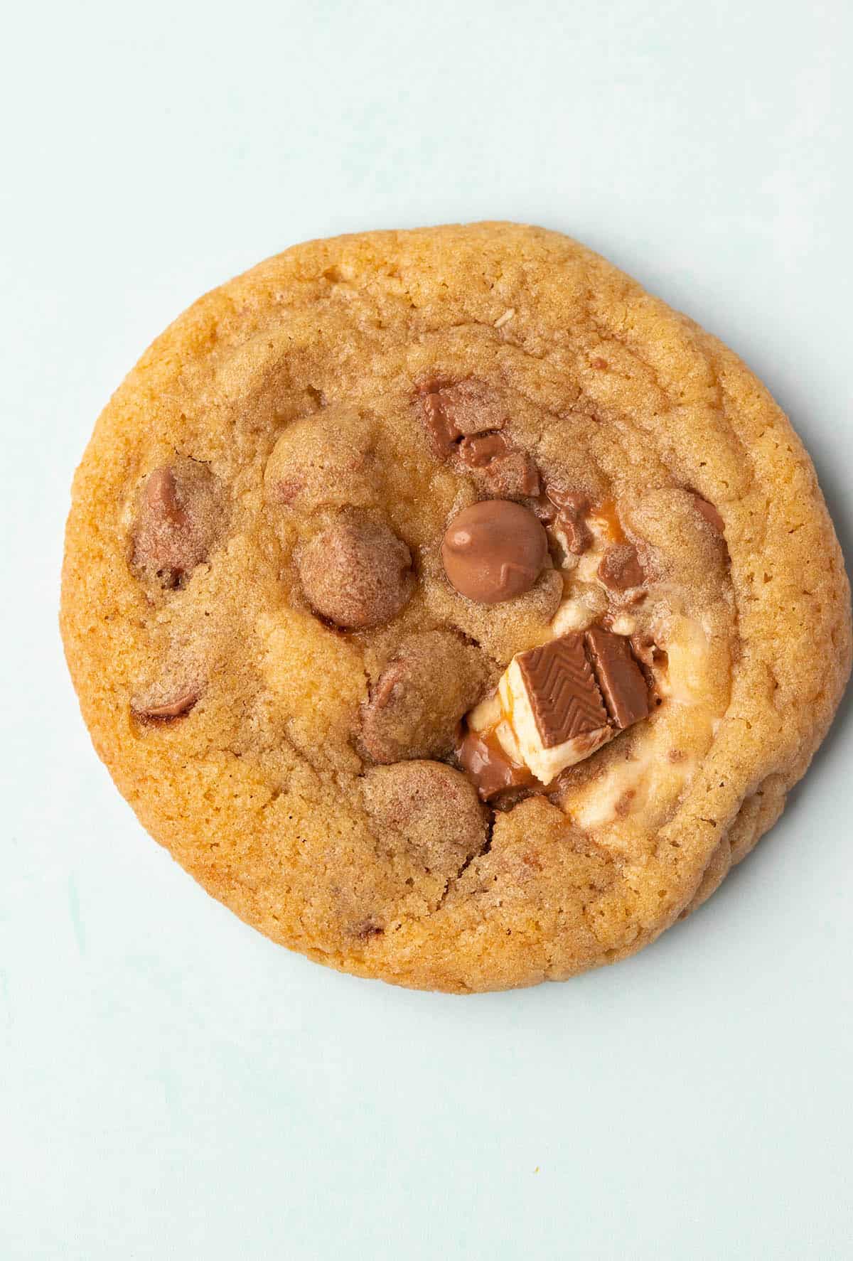 Top view of a Snickers Cookie on a green background.