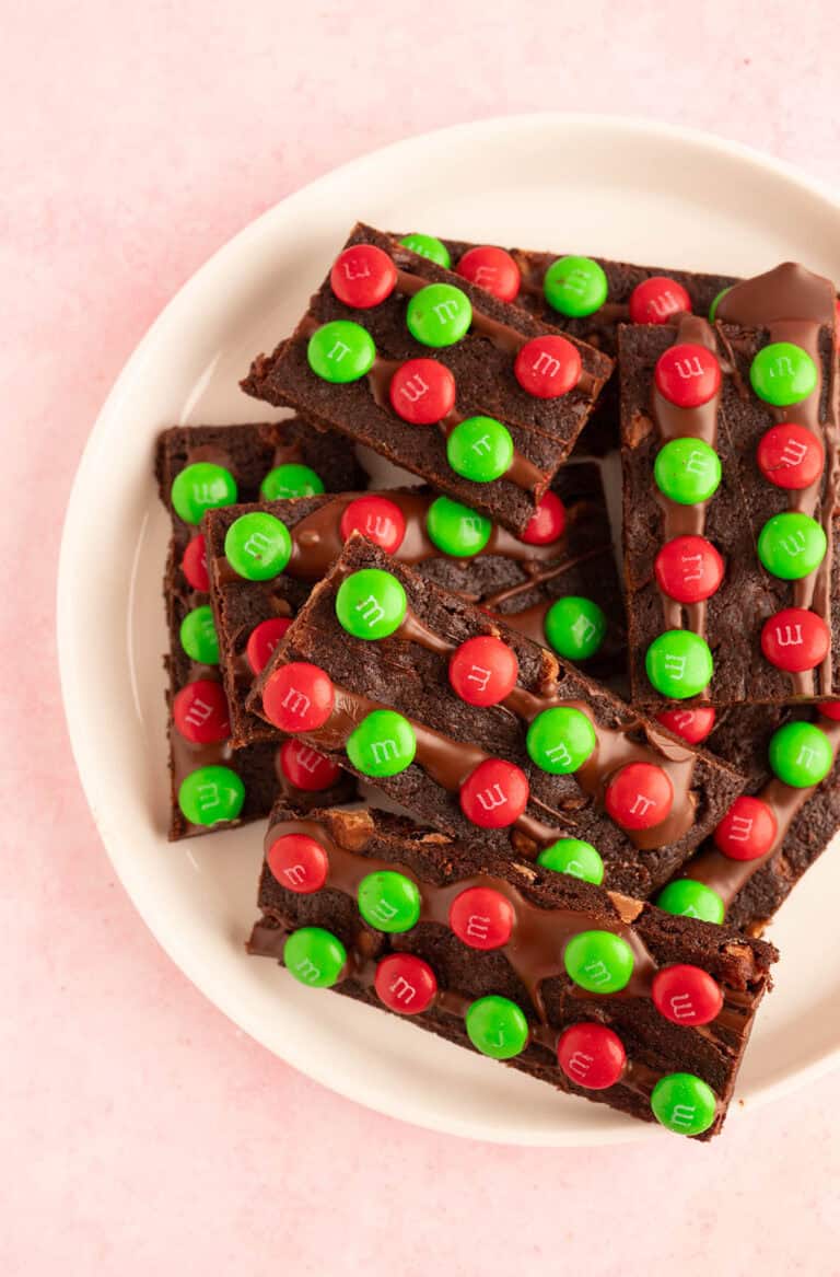 Top view of white plate filled with brownie bark covered in red and green M&M's.