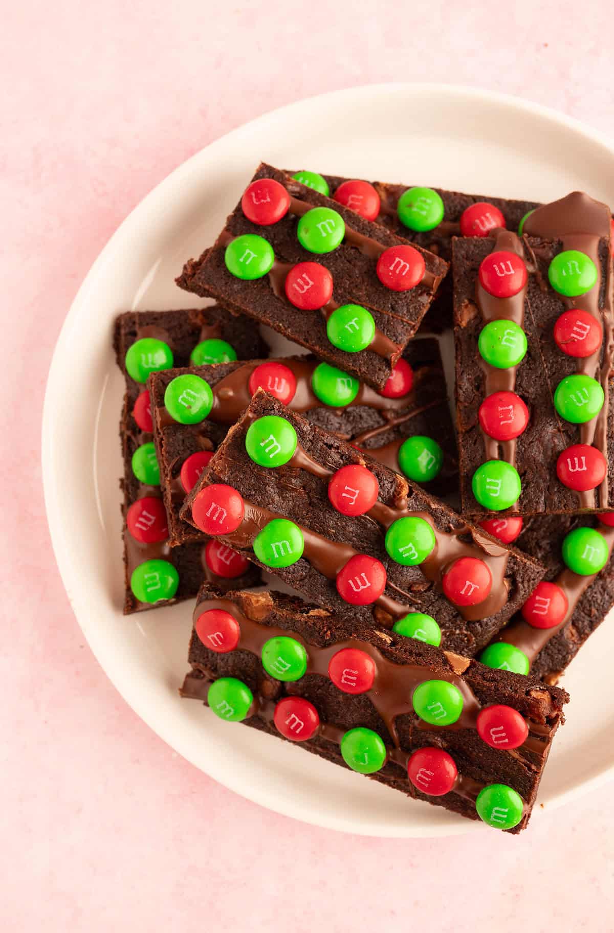 Top view of white plate filled with brownie bark covered in red and green M&M's.