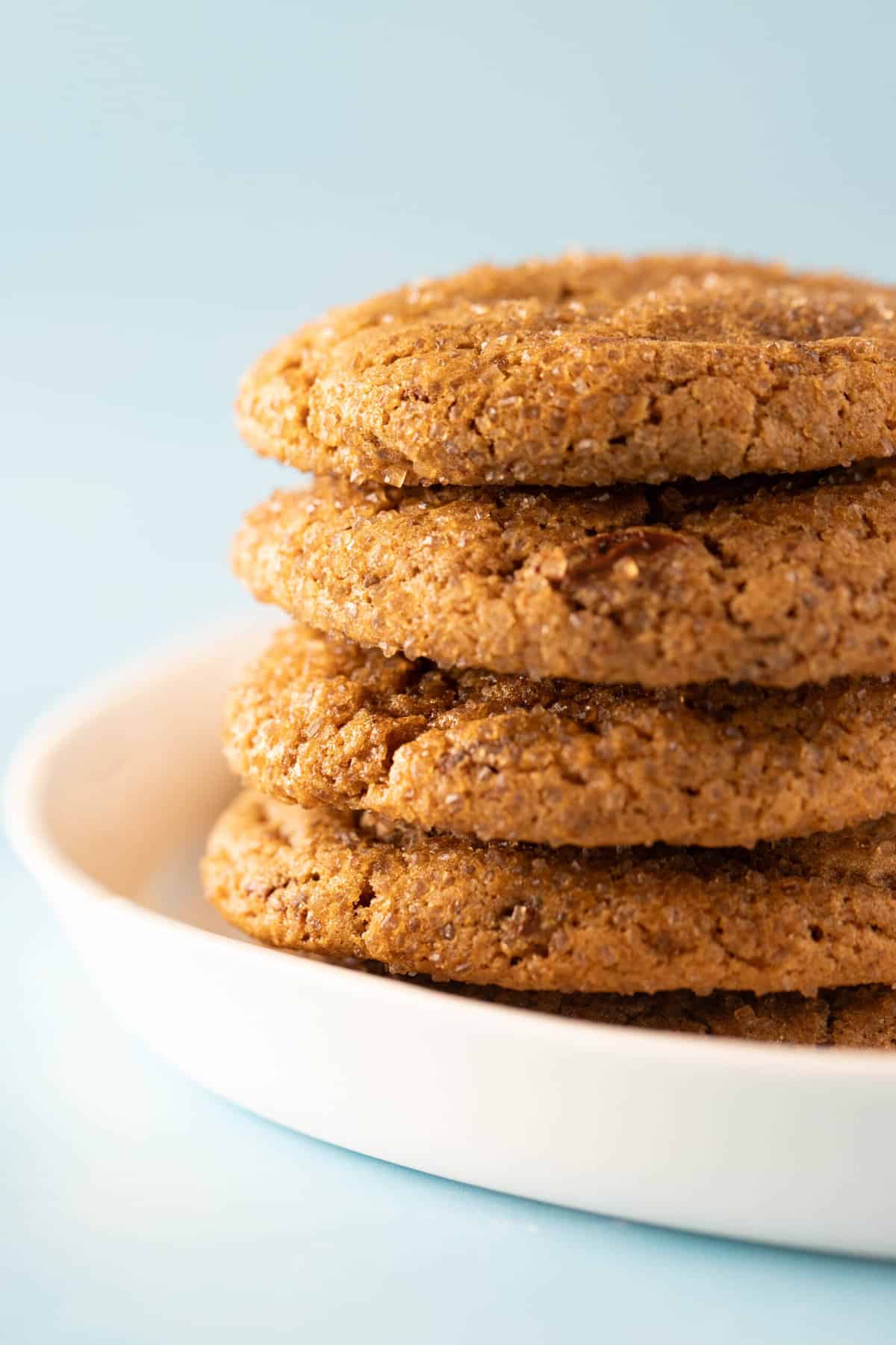 A tall stack of homemade Molasses Cookies on a white plate. 