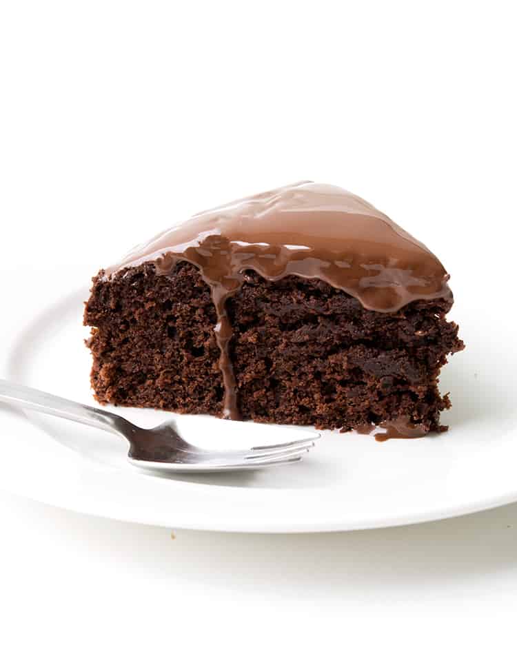 A slice of Dairy Free Chocolate Cake on a white plate