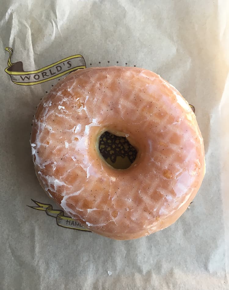 Glazed donut on a brown paper bag