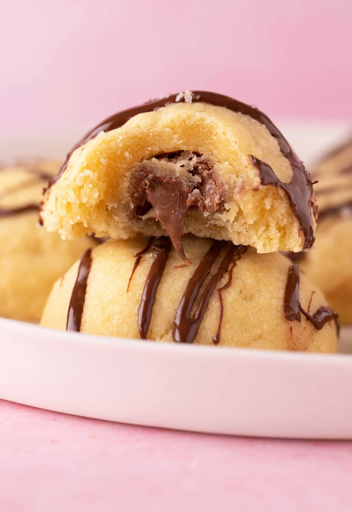 A stack of shortbread cookies with gooey chocolate in the middle.