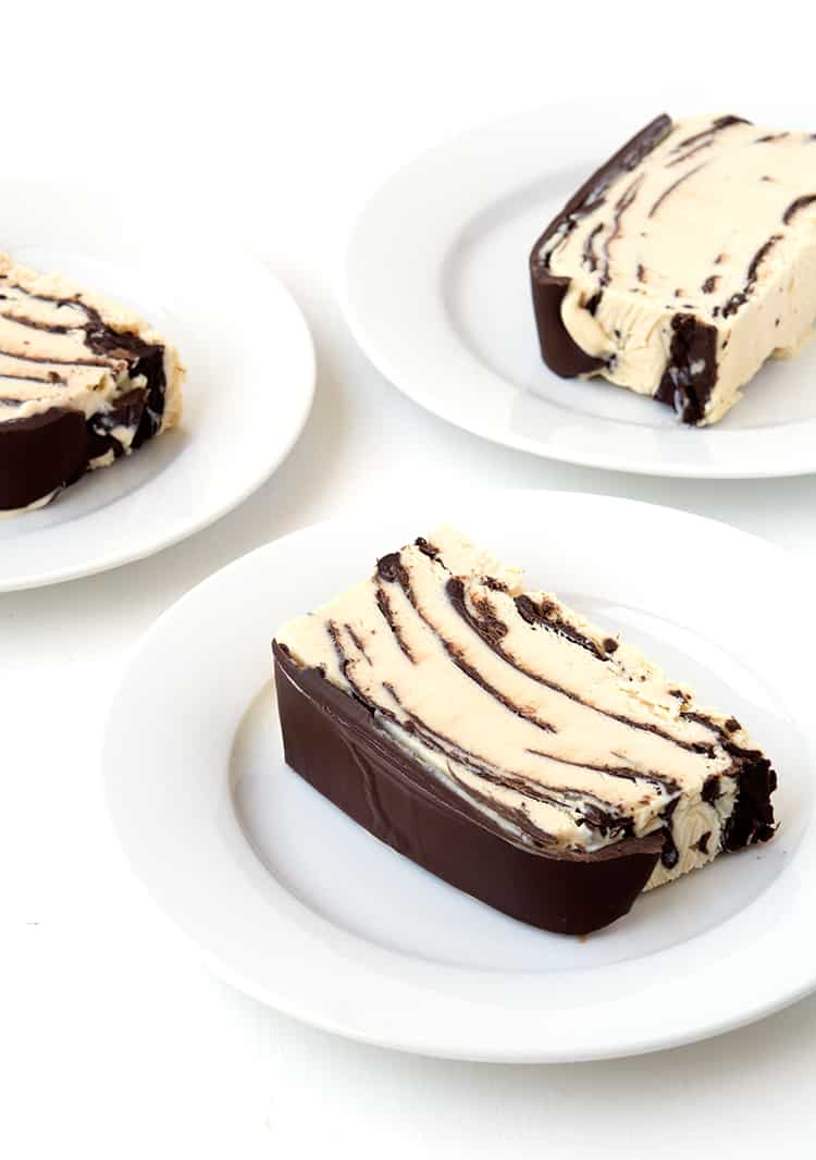 Slices of peanut butter ice cream cake on white plates