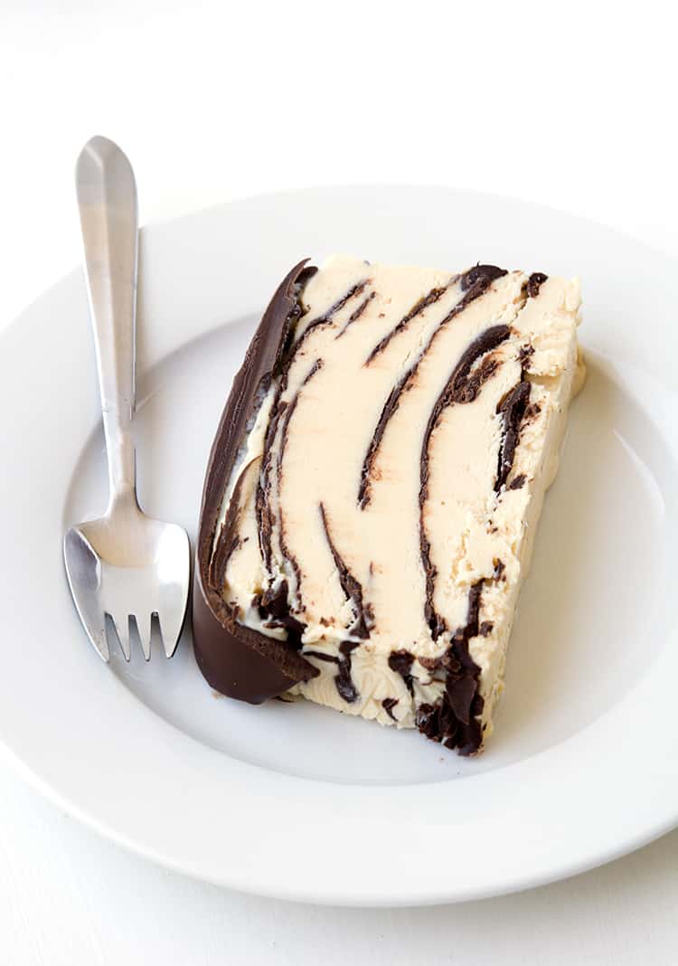 A slice of peanut butter ice cream cake on a white plate