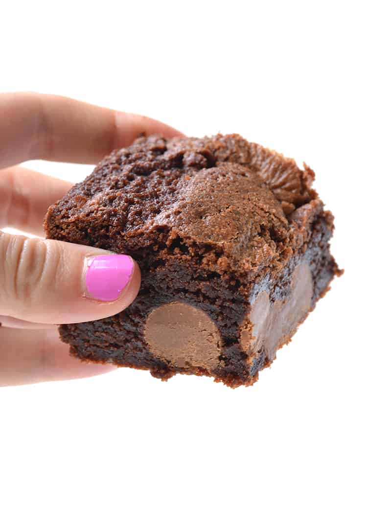 Hand holding a chocolate brownies stuffed with mini Easter eggs