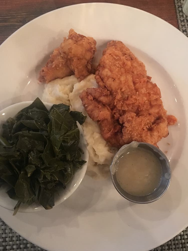 Plate of fried chicken and collard greens from Poogan's Porch