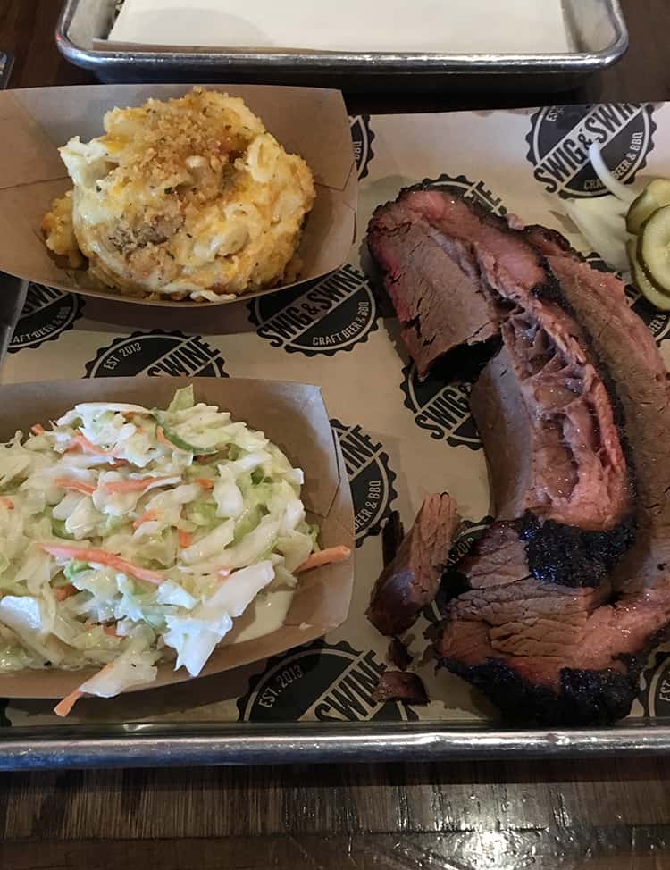 A plate of American barbecue, brisket, coleslaw and mac and cheese