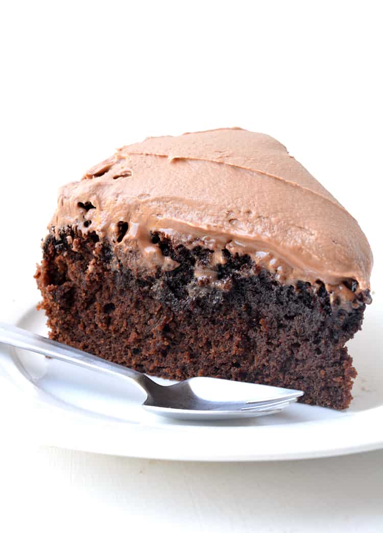 A slice chocolate mud cake on a white plate