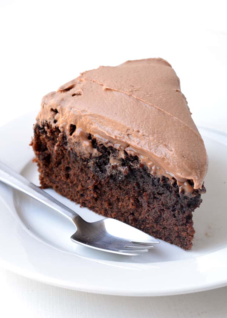 A slice of chocolate mud cake on a white plate