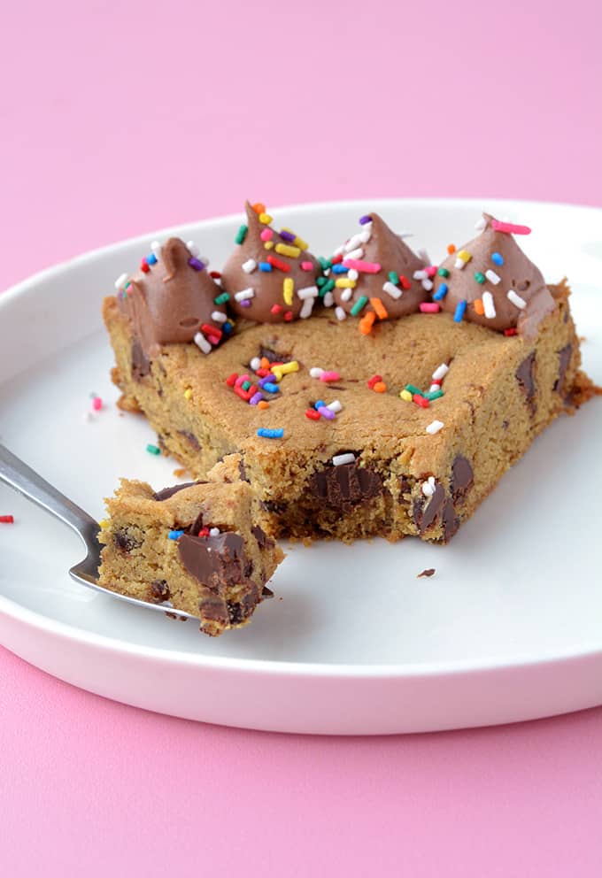 A slice of Chocolate Chip Cookie Cake with a bite taken out of it
