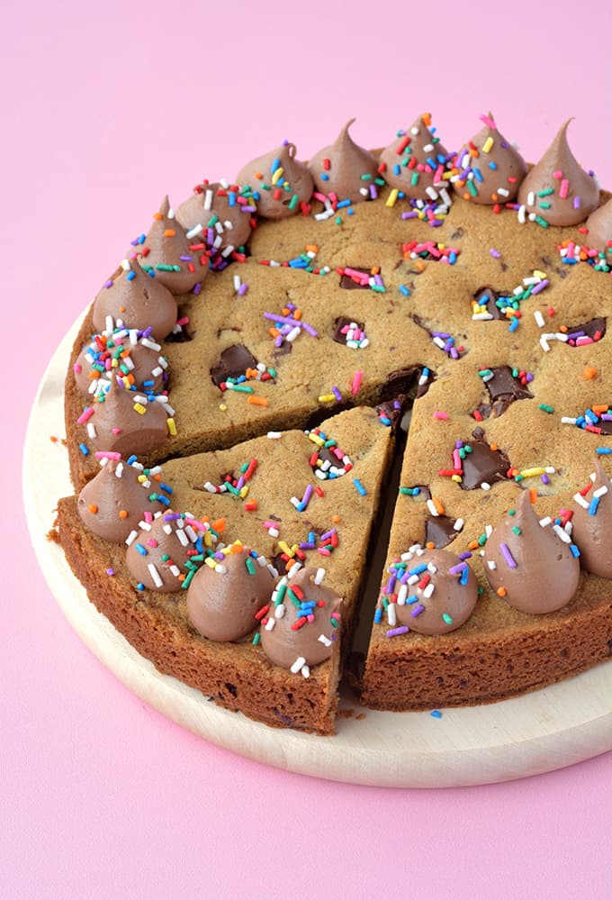 A Giant Chocolate Chip Cookie Cake with a slice taken out of it