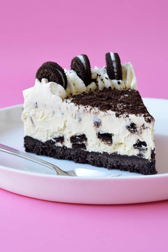 A slice of Oreo Cheesecake on a white plate