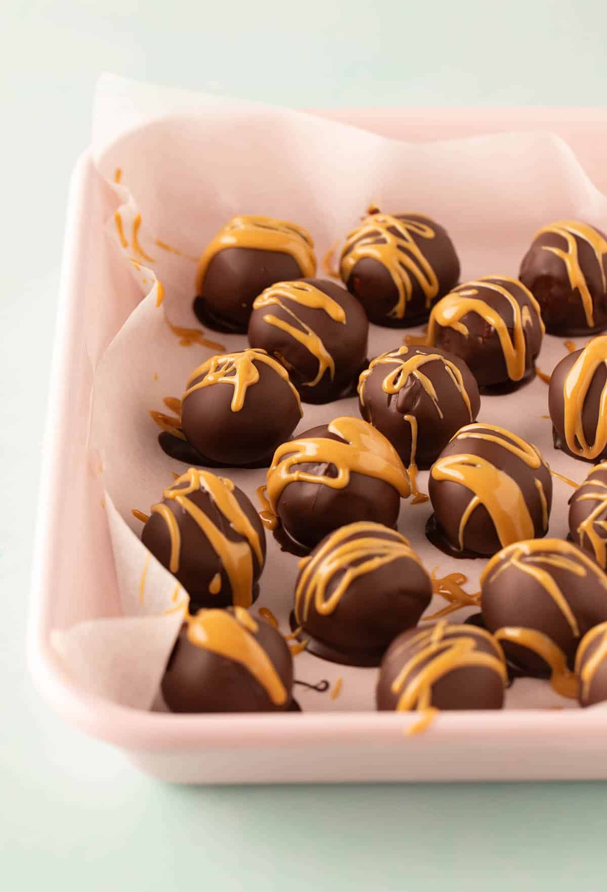A pink tray filled with homemade peanut butter balls. 