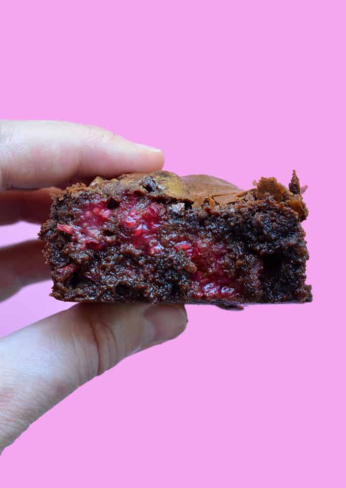 A hand holding a Raspberry Chocolate Brownies