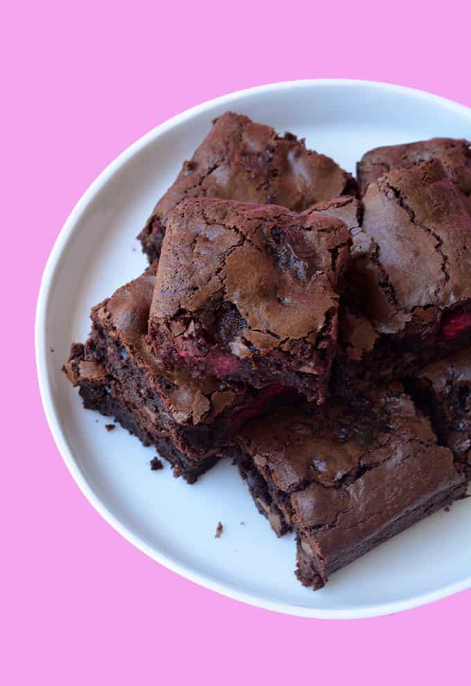 A pile of Raspberry Chocolate Brownies on a white plate