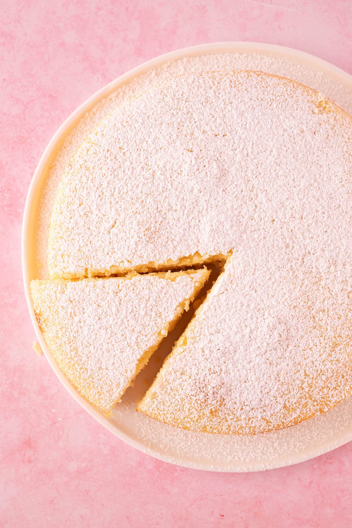 Top view of a Lemon Ricotta Cake dusted with powdered sugar. 