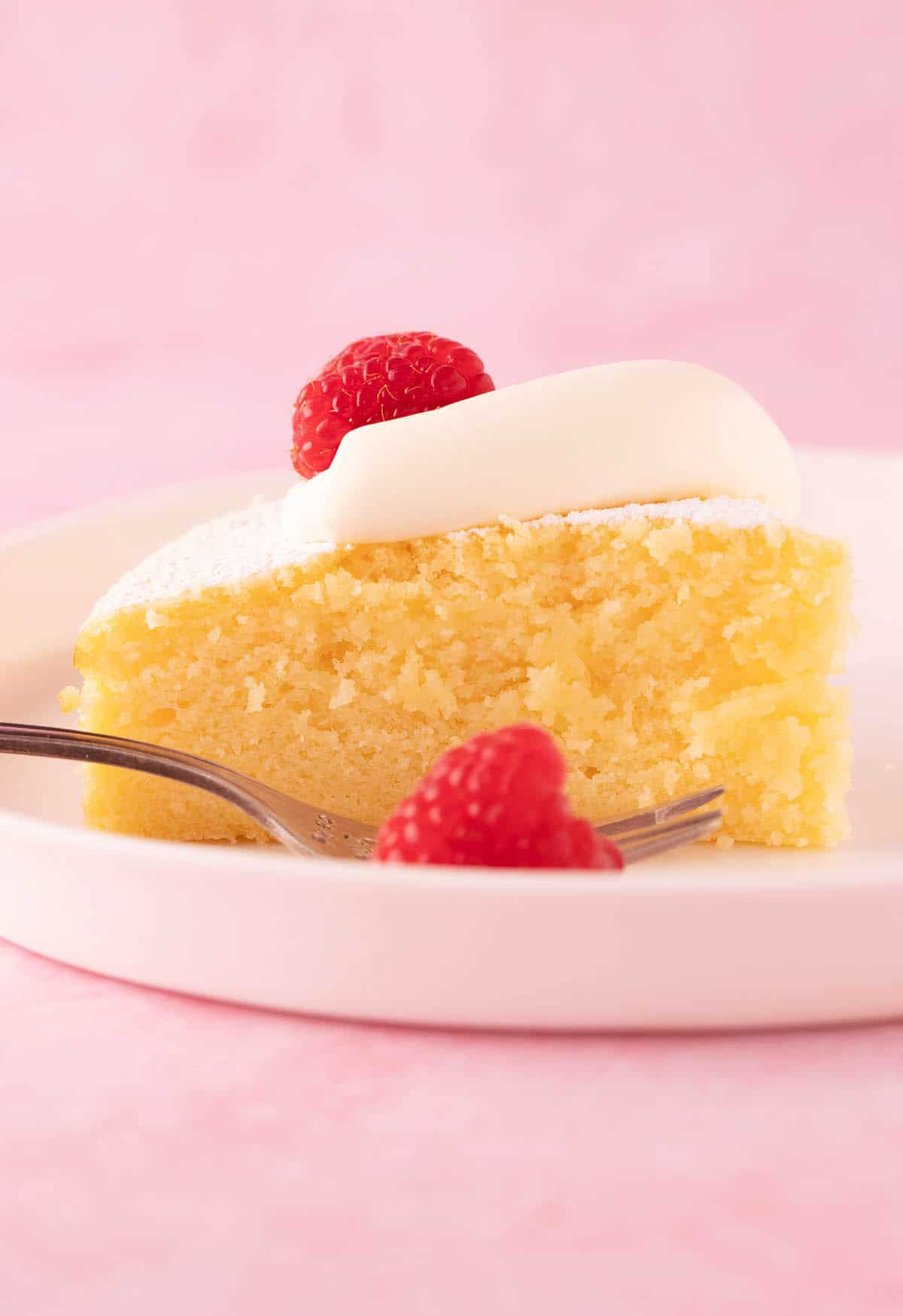 A beautiful pieces of Lemon Ricotta Cake served with fresh raspberries.