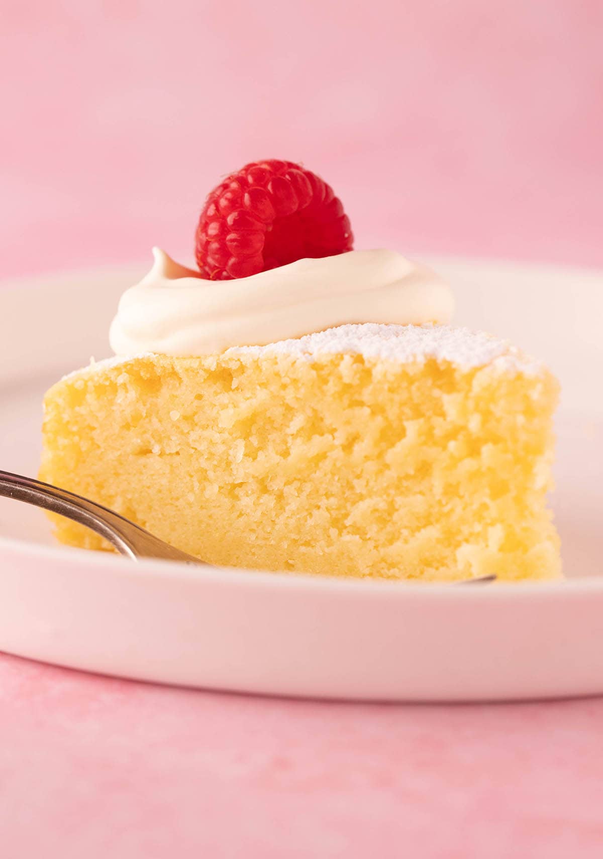 A big slice of homemade Lemon Ricotta Cake on a white plate