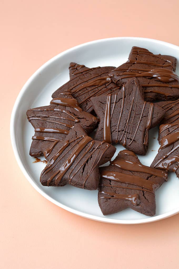 A plate of Chocolate Gingerbread Stars drizzled with chocolate