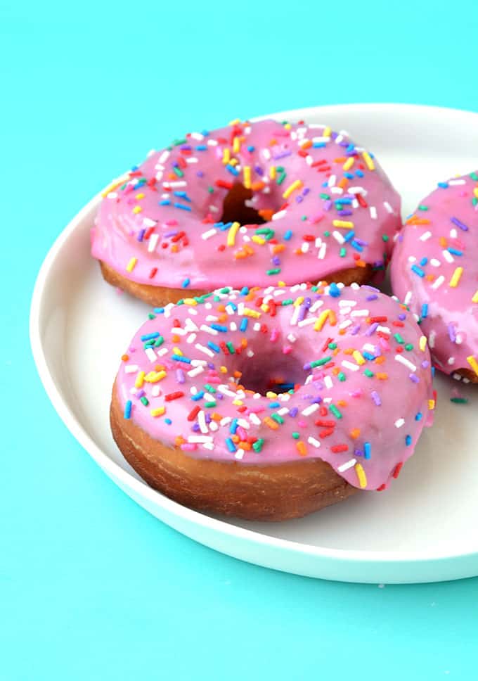 Close up of a plate of pink glazed donuts
