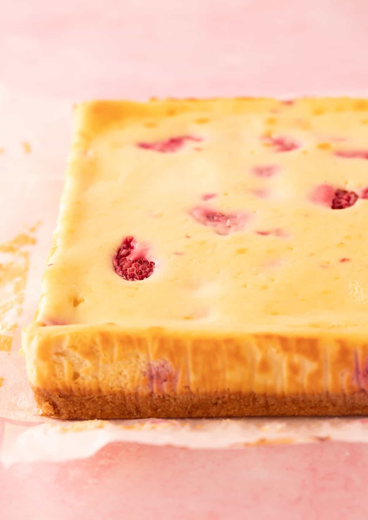 Thick homemade White Chocolate Raspberry Cheesecake Bars fresh from the oven. 