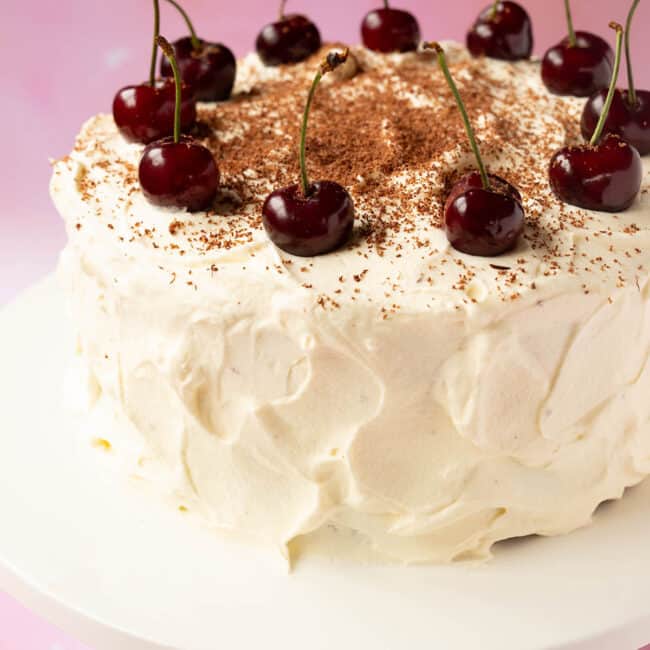 A stunning Black Forest Cake decorated with fresh cherries.