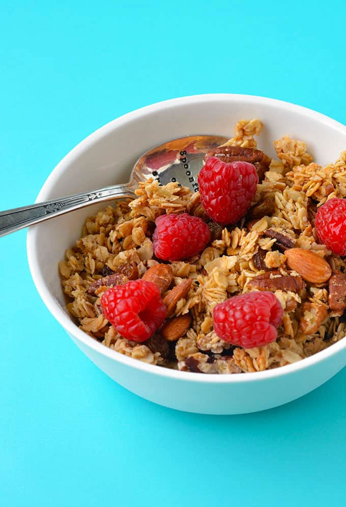 A bowl of homemade granola topped with fresh raspberries