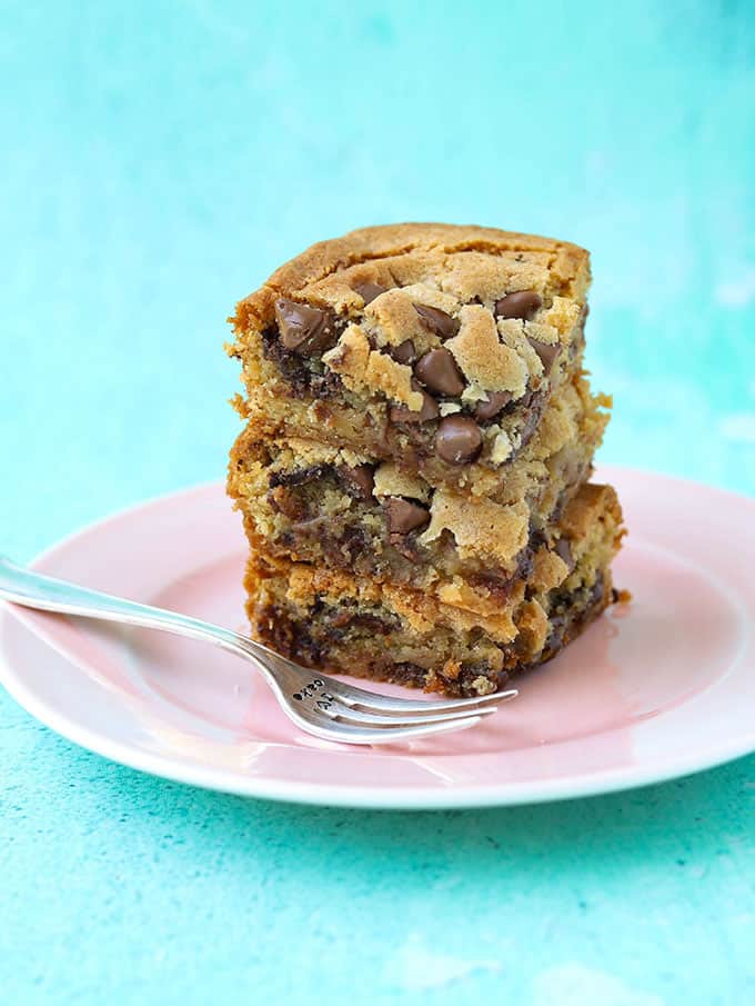A stack of chocolate chip cookie bars on a pink plate