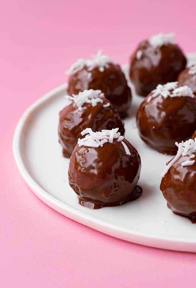 Chocolate coconut truffles sitting on a white plate