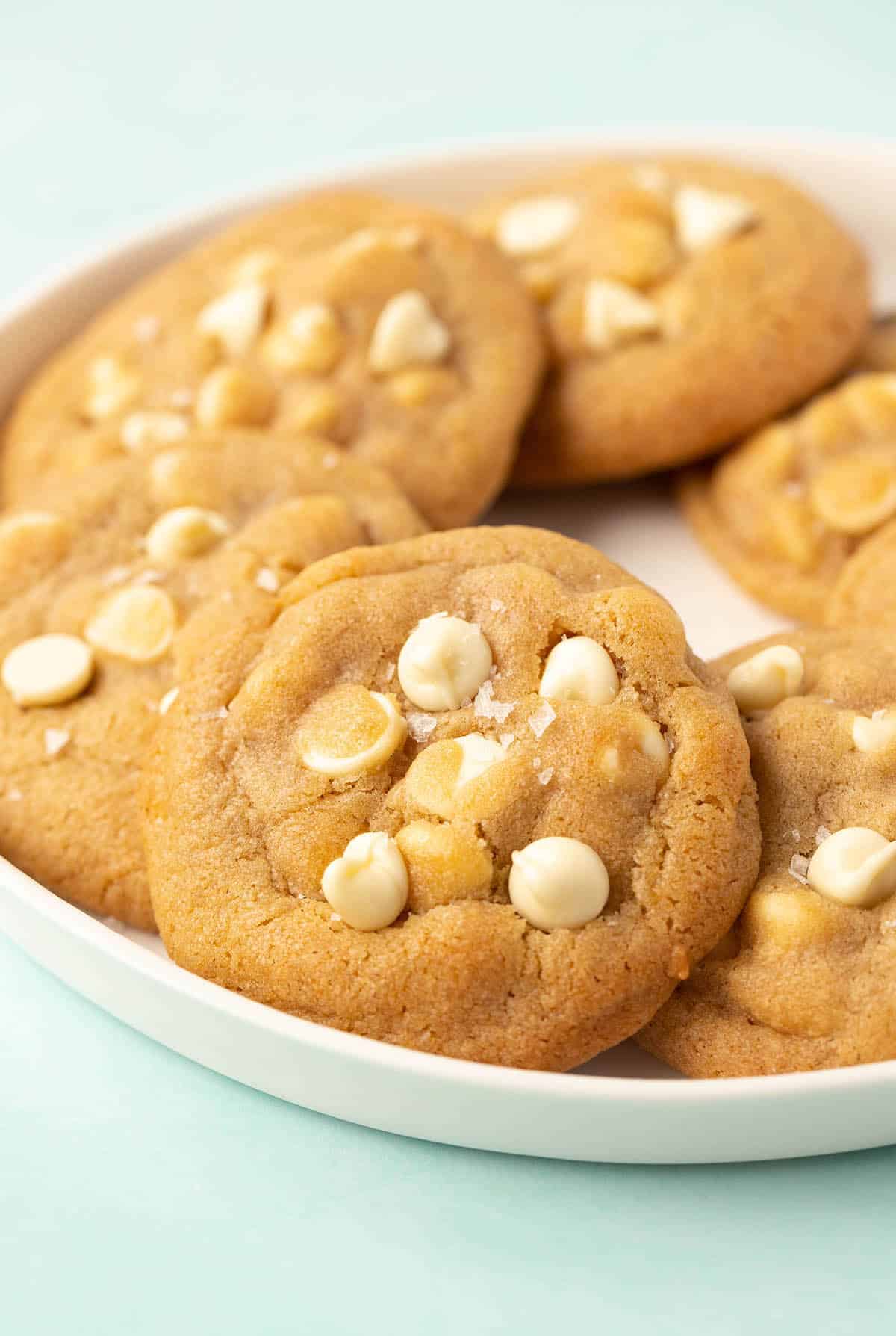 A white plate filled with homemade white chocolate chip cookies.