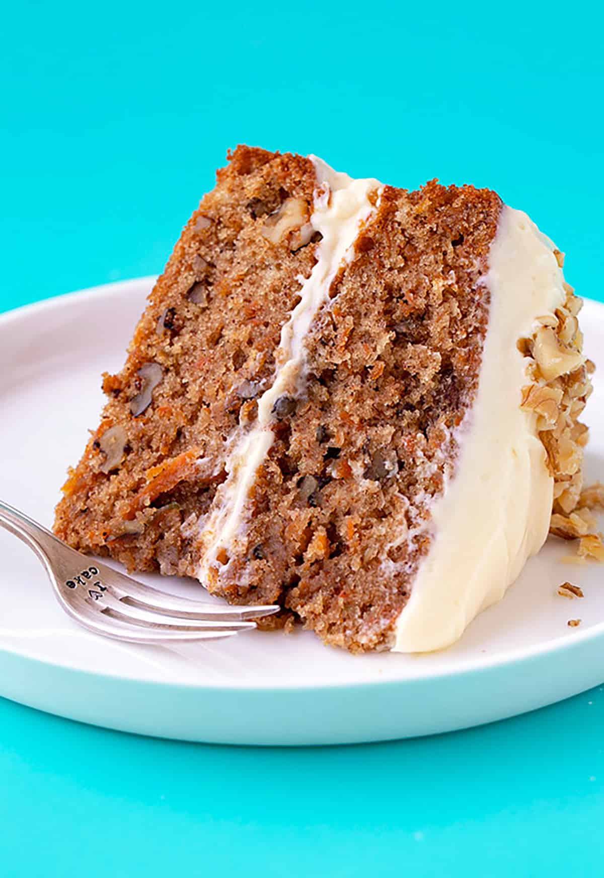 Two layers of carrot cake topped with walnuts.