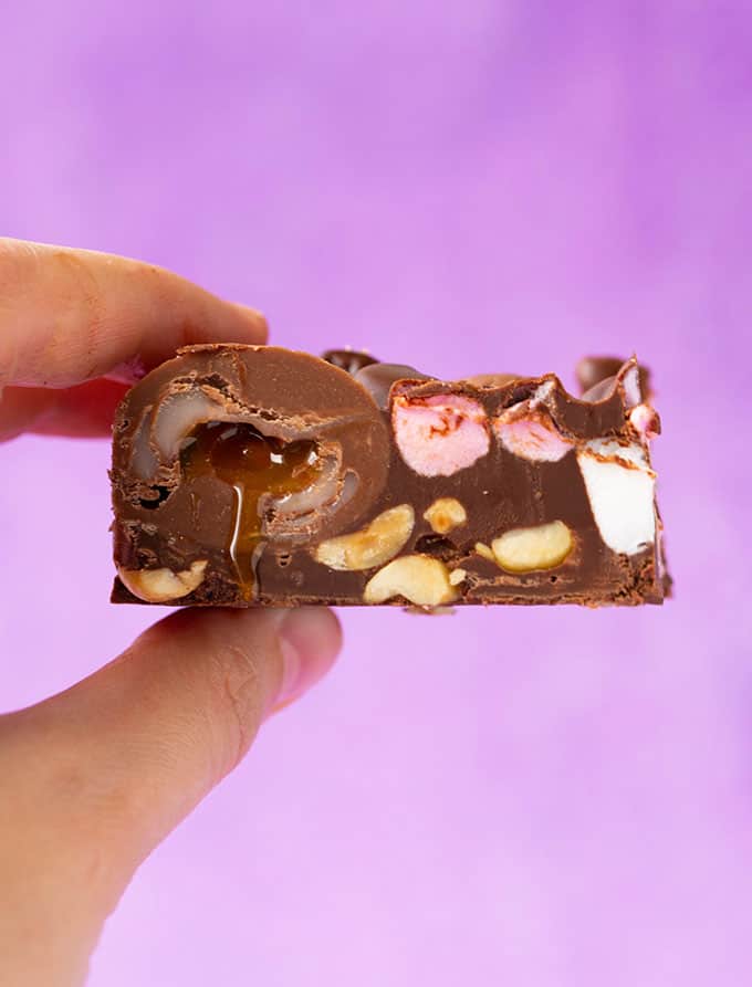 A hand holding a piece of Creme Egg Rocky Road