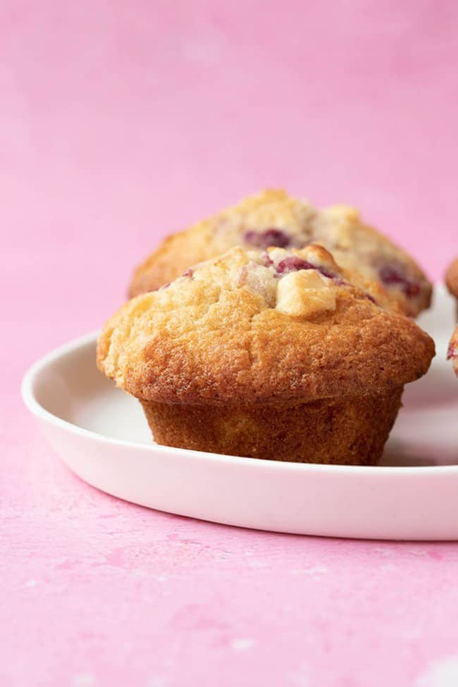 Homemade raspberry white chocolate muffin on a white plate