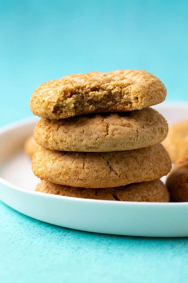 A stack of peanut butter cookies on a blue background