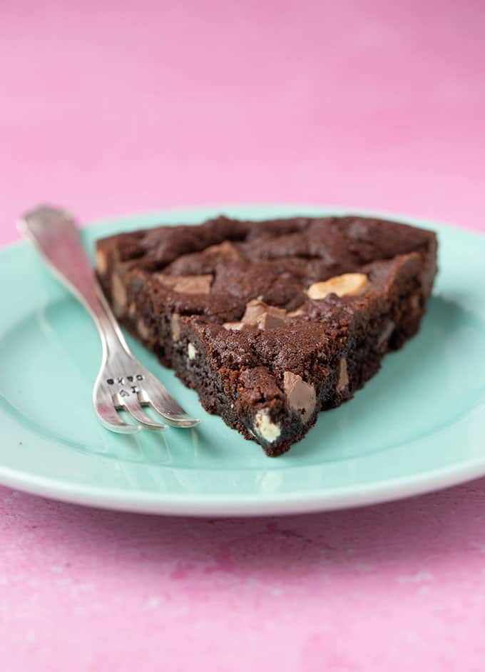 A close up of a slice of Triple Chocolate Cookie Cake on a green plate