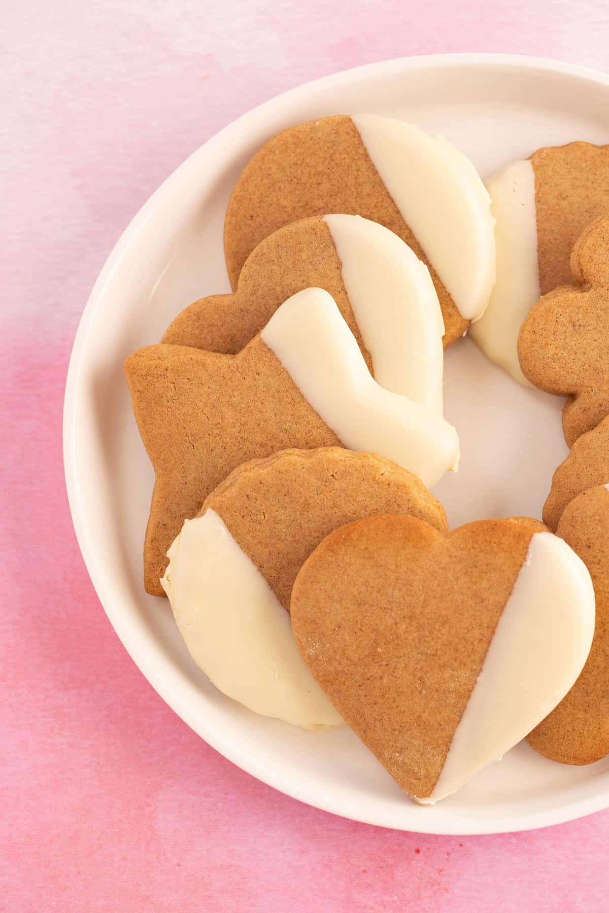 Gorgeous cut-out Honey Cookies on a pink backdrop. 