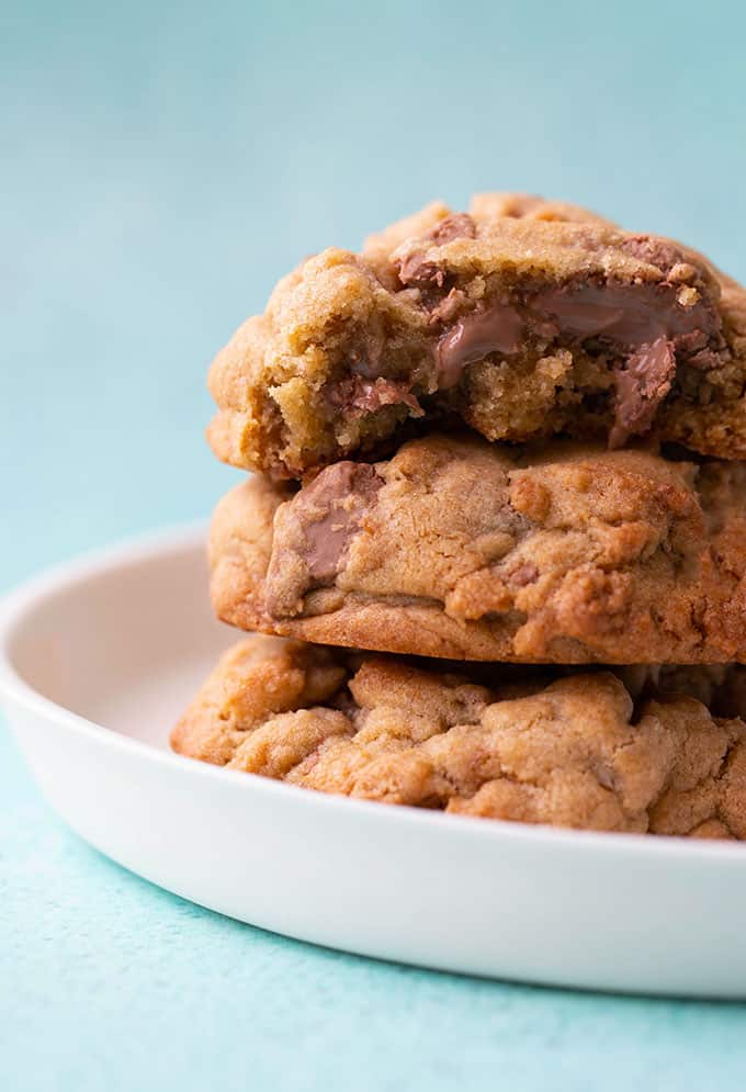 A stack of Levain bakery chocolate chip cookies on a white plate