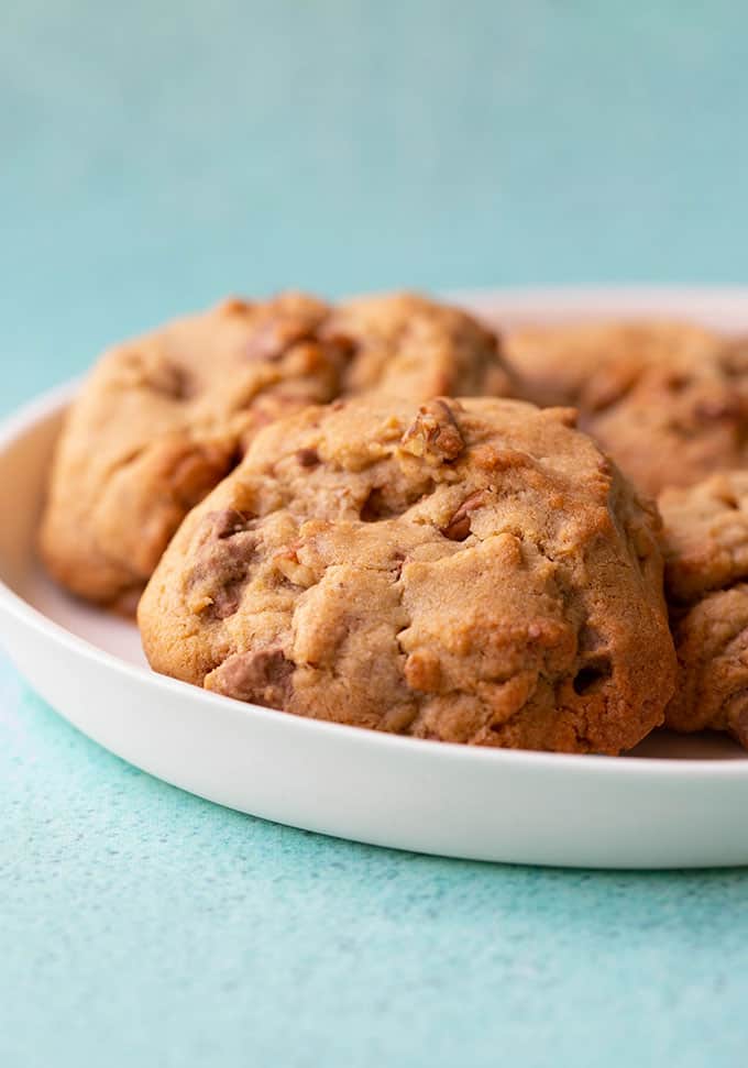 A white plate filled with thick and chewy chocolate chip cookies
