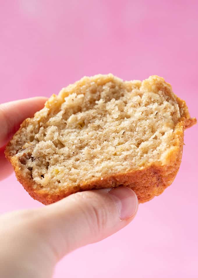 A hand holding a Banana Nut Muffin that's be sliced in half