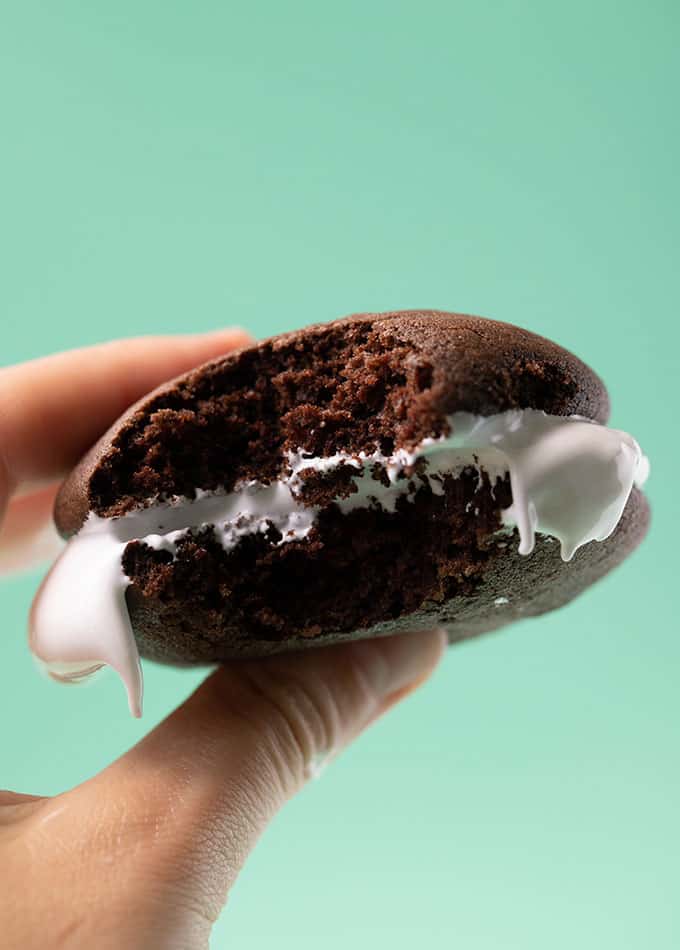A hand holding a homemade chocolate whoopie pie