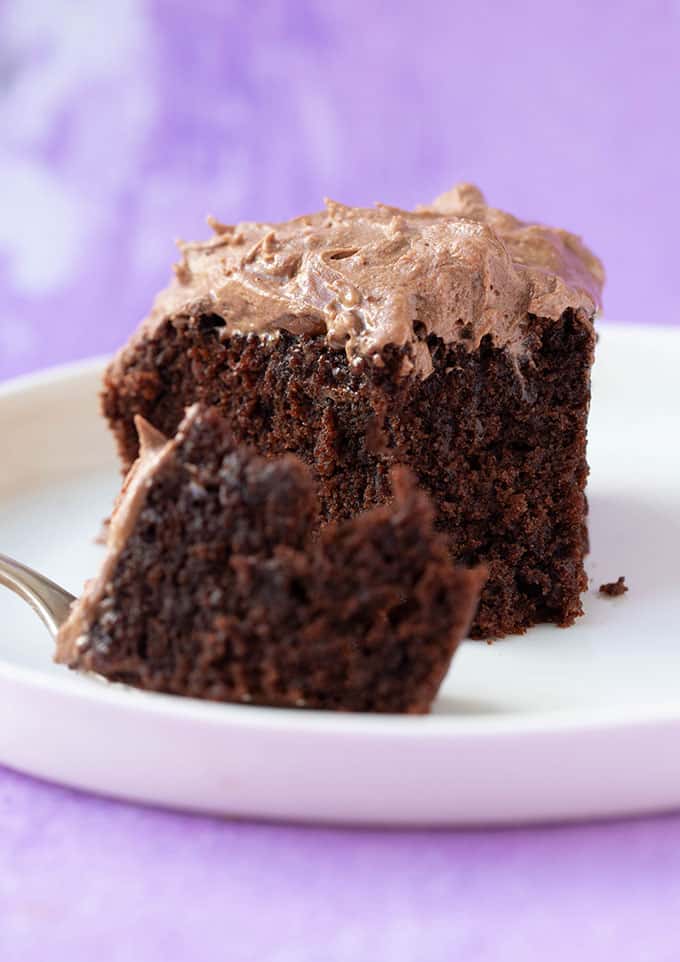 A slice of gluten free chocolate cake with a bite taken out of it