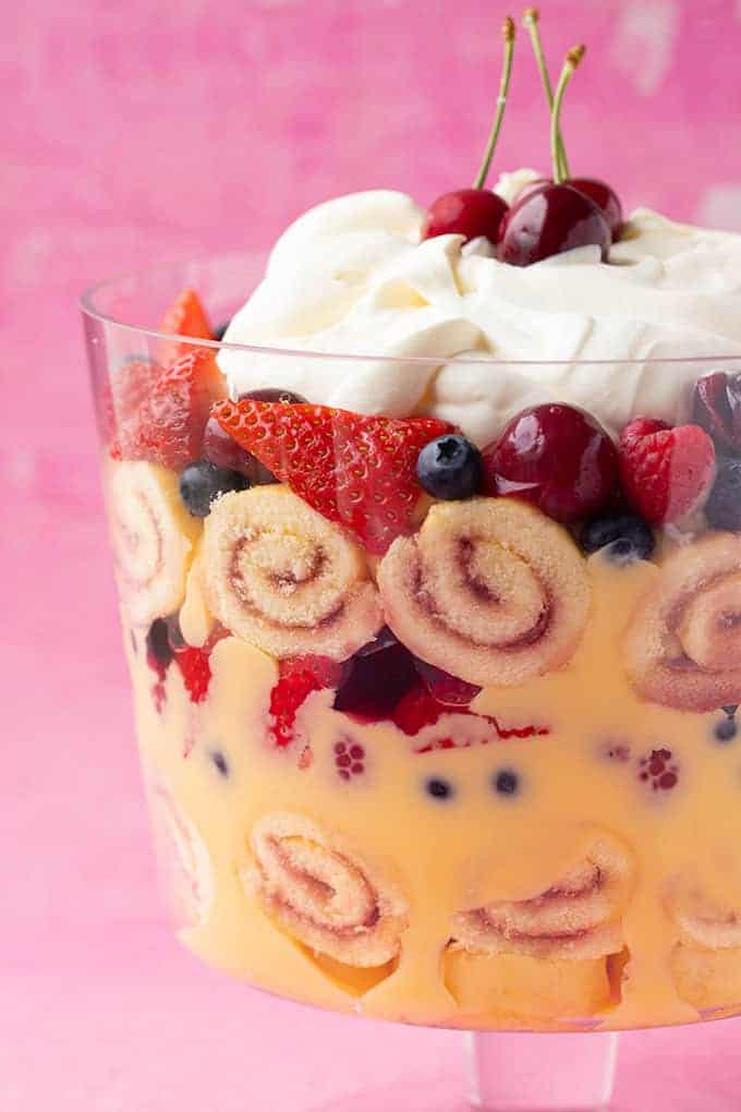 Close up of a berry trifle on a pink background