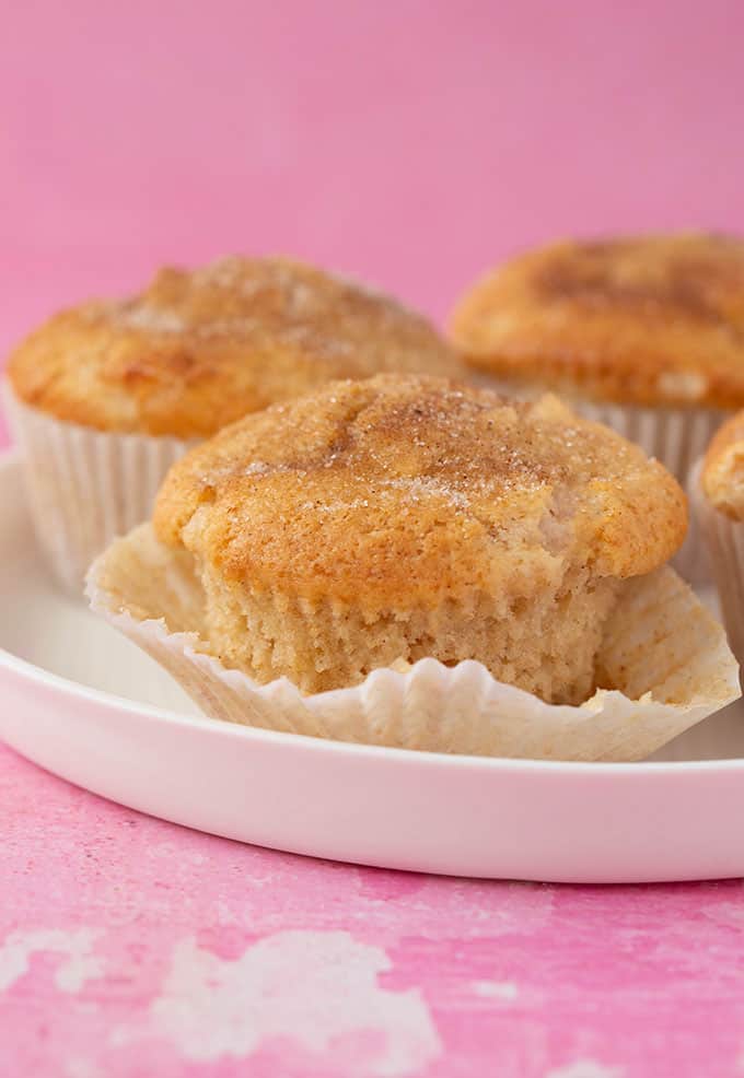 Homemade Apple Muffins slightly unwrapped on a white plate