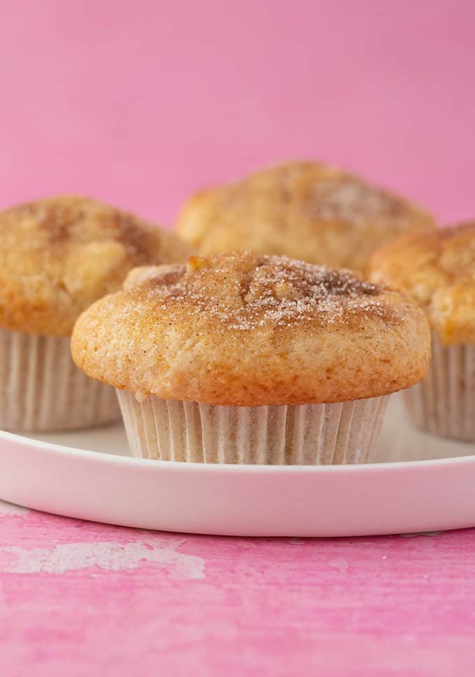 Close up of a plate of homemade Apple Muffins on a pink background