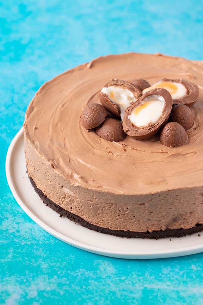 A beautiful homemade Creme Egg Cheesecake on a bright blue background