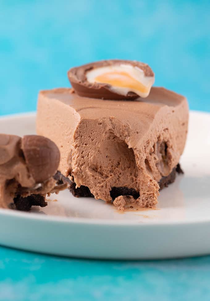 A slice of Creme Egg Cheesecake with a bite taken out of it to show creamy centre